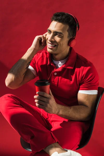 Stylish Mixed Race Man Headphones Sitting Holding Coffee Talking Smartphone — Stock Photo, Image