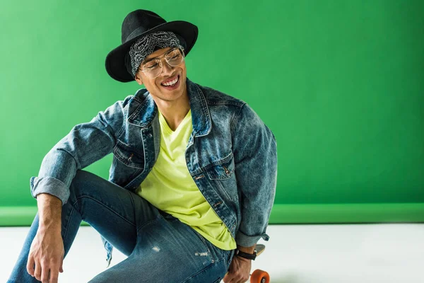 Stilvoller Mixed Race Mann Sitzt Lächelt Und Posiert Auf Grün — Stockfoto