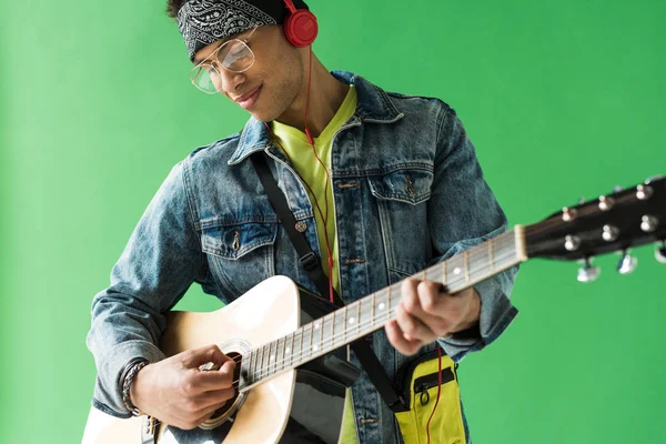 Handsome Mixed Race Man Denim Headphones Playing Acoustic Guitar Green — Stock Photo, Image