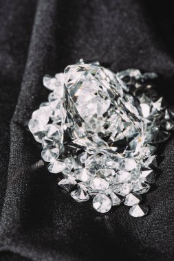 pile of sparkling pure diamonds on black shiny cloth  clipart