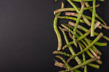 siyah arka plan üzerine dağılmış yeşil pişmemiş kuşkonmaz Üstten Görünüm