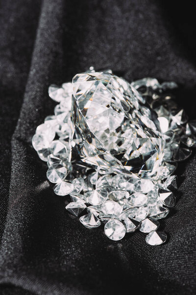 pile of sparkling pure diamonds on black shiny cloth 