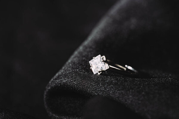 engagement ring with pure shiny diamond on black cloth 