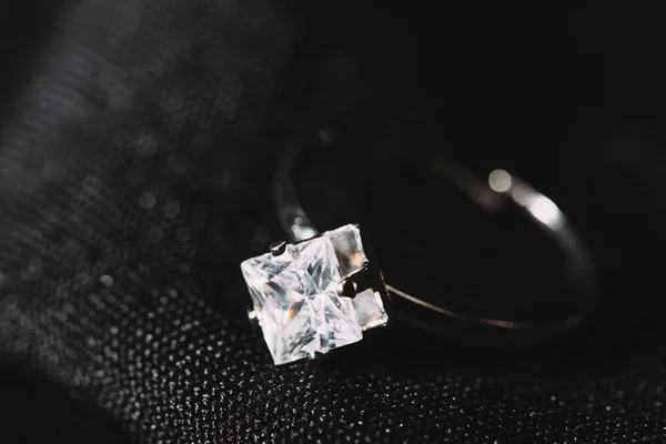 黒い布に純粋な輝くダイヤモンド婚約指輪 — ストック写真
