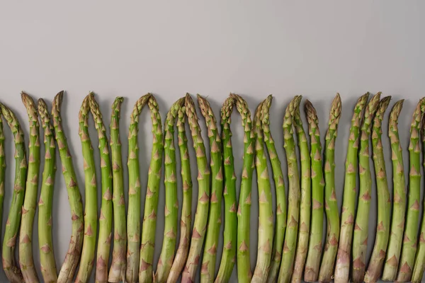 Top View Green Raw Asparagus Row Grey Background — Stock Photo, Image