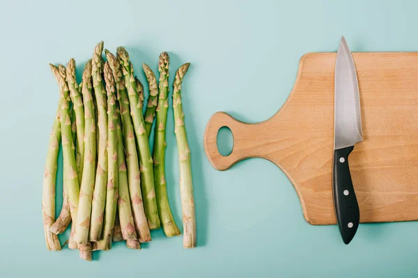 Top View Green Raw Asparagus Wooden Cutting Board Knife Blue — Stock Photo, Image