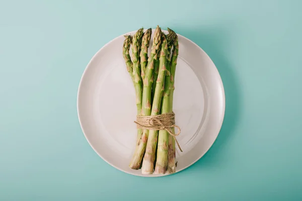 Top View Green Raw Asparagus Tied Rope White Plate Blue — Stock Photo, Image