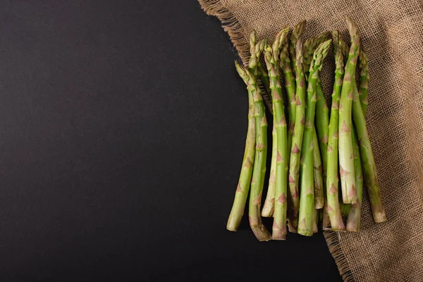 Top View Green Asparagus Sackcloth Black Background — Stock Photo, Image
