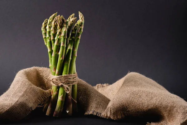 Bunch Green Raw Asparagus Tied Rope Sackcloth Black Background — Stock Photo, Image