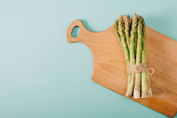 Top View Green Raw Asparagus Wooden Cutting Board Blue Background — Stock Photo, Image