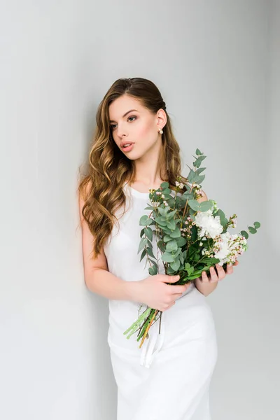 灰色に花の花束を保持する美しい少女 — ストック写真