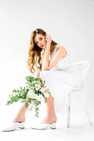 ドレスを着て椅子に座ってとユーカリと花の花束を持って美しい若い女性の白の葉します — ストック写真