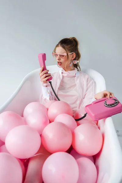Meisje Zonnebril Retro Telefoon Kijken Liggend Badkuip Met Roze Lucht — Stockfoto