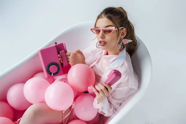 Jovem Mulher Óculos Sol Olhando Para Telefone Retro Rosa Enquanto — Fotografia de Stock