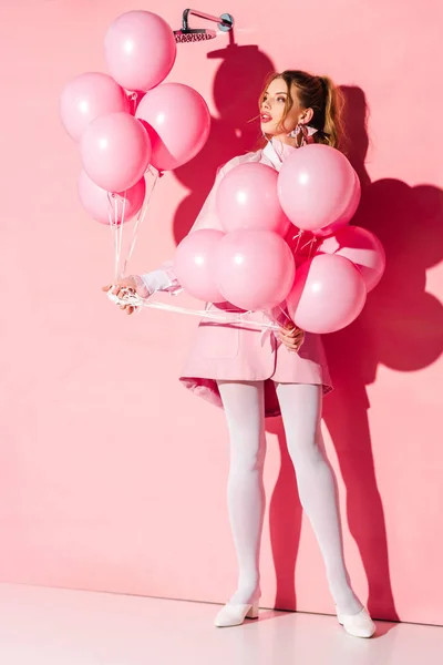 Ελκυστική Νεαρή Γυναίκα Κρατώντας Αέρα Μπαλόνια Ενώ Στέκεται Για Ροζ — Φωτογραφία Αρχείου