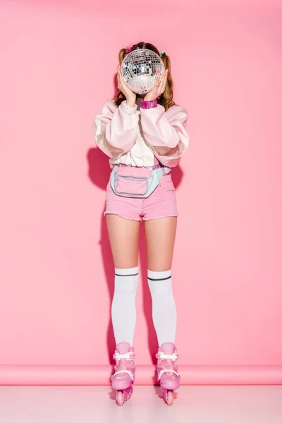 女孩覆盖脸与闪亮的迪斯科球 而站在溜冰鞋粉红色 — 图库照片