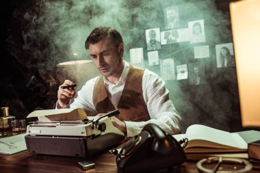 Detective holding cigar while using typewriter in dark office clipart