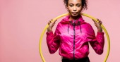 Panoramaaufnahme der schönen afrikanisch-amerikanischen Sportlerin mit Hula-Hoop-Reifen, die isoliert auf rosa Kamera schaut
