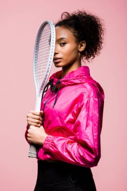 Tenis raketi tutarak ve pink izole kamera bakıyor güzel Afro-Amerikan sporcumuz