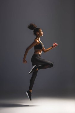 güzel atletik Afro-Amerikan sporcumuz siyah üzerine atlama yan görünüm