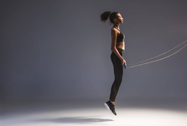 atletik Afro-Amerikan sporcumuz Grey kopya alanı ile ip atlama ile egzersiz