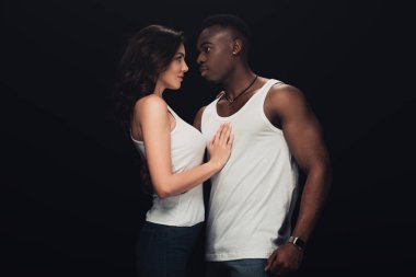 beautiful sensual interracial couple in white tank tops isolated on black clipart
