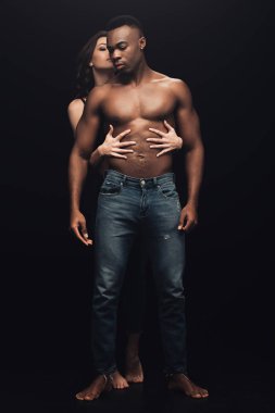 güzel seksi kadın sarılma gömleksiz Afrikalı Amerikalı adam kot siyah üzerinde izole