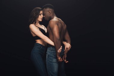güzel seksi kadın kucaklıyor gömleksiz Afrikalı Amerikan adam kelepçe içinde siyah üzerinde kopya alanı ile izole