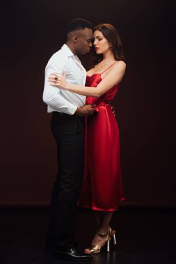 siyah üzerinde izole kırmızı elbise güzel kadın kucaklayan yakışıklı Afrikalı Amerikalı adam