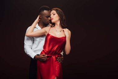 Afrikalı Amerikan adam kopya alanı ile siyah üzerinde izole kırmızı elbise güzel baştan çıkarıcı kadın kucaklayan
