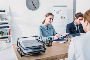 iş röportajında kadına bakarken neşeli HR holdıng Pano ve kalem 