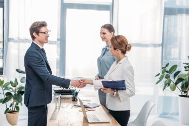 happy employee shaking hands with recruiter on job interview  clipart