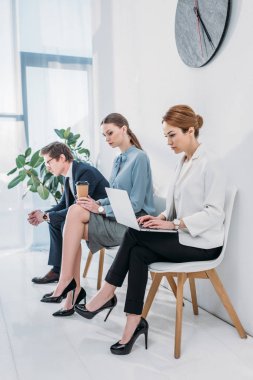 güzel kadın kağıt fincan ve gözlük adam ile çekici çalışan yakın laptop kullanarak 