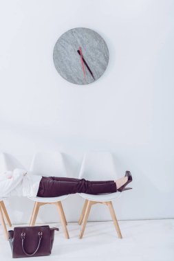 iş görüşmesi beklerken sandalyenin üzerinde yatan kadının kırpılmış görünümü 