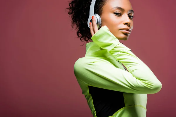 Atractiva Deportista Afroamericana Auriculares Mirando Cámara Aislada Marrón Con Espacio —  Fotos de Stock