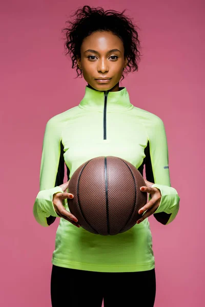 Piękne African American Sportsmenka Patrząc Kamery Trzymając Koszykówki Różowym Tle — Zdjęcie stockowe
