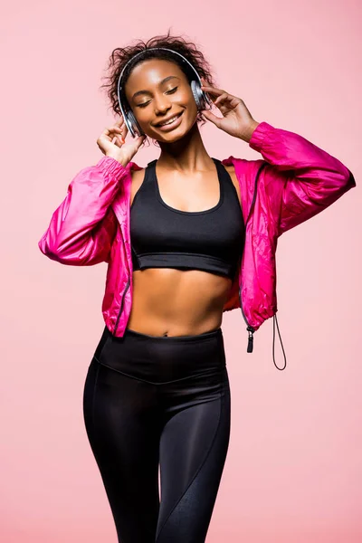 Mooie Lachende Afro Amerikaanse Sportvrouw Hoofdtelefoon Luisteren Muziek Geïsoleerd Roze — Stockfoto