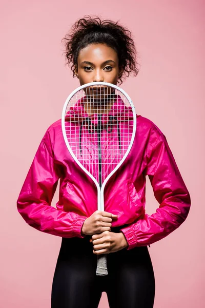 美丽的非洲裔美国女运动员摆姿势与网球拍孤立在粉红色 — 图库照片