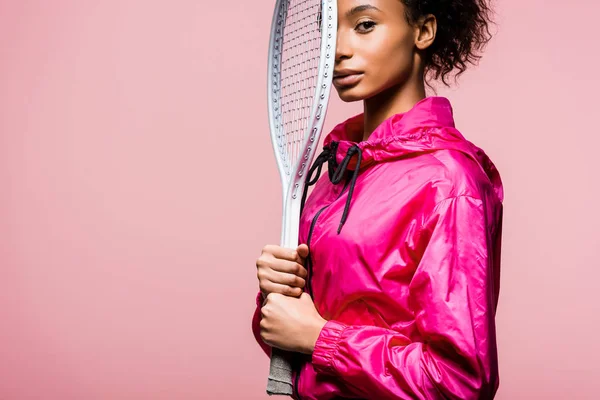 コピー スペースを持つピンクの分離したテニス ラケットを押しカメラ目線美しいアフリカ系アメリカ人のスポーツ選手 — ストック写真