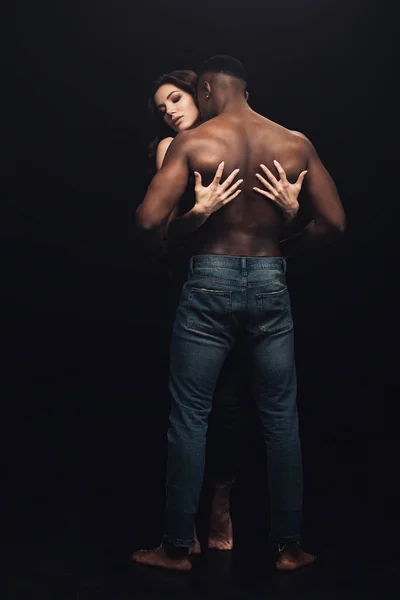 黒人に孤立した上半身裸アフリカ系アメリカ人男性を抱きしめた美しいセクシーな女性のバックビュー — ストック写真