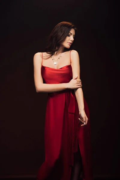 美丽的性感的女人在红色礼服摆姿势孤立的黑色 — 图库照片