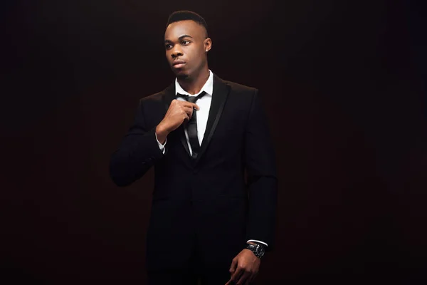 Красивий Модний Афроамериканський Чоловік Костюмі Регулює Краватку Ізольовано Чорному — стокове фото