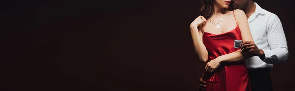 Панорамний Знімок Афроамериканця Який Тримає Презерватив Приймає Жінку Червоній Сукні — стокове фото