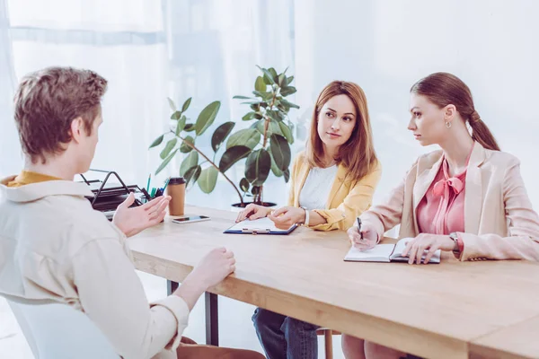 Homem Falando Gesticulando Perto Recrutadores Atraentes Entrevista Emprego — Fotografia de Stock