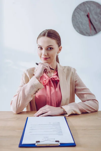 Glad Och Vacker Rekryterare Håller Penna När Sitter Nära Urklipp — Stockfoto