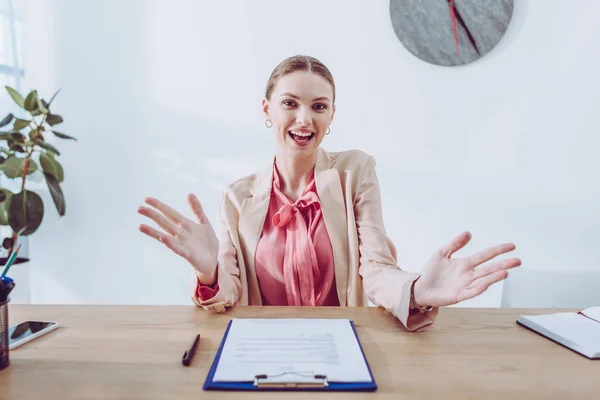 Cheerful Recruiter Gesturing While Sitting Clipboard Looking Camera — Stock Photo, Image