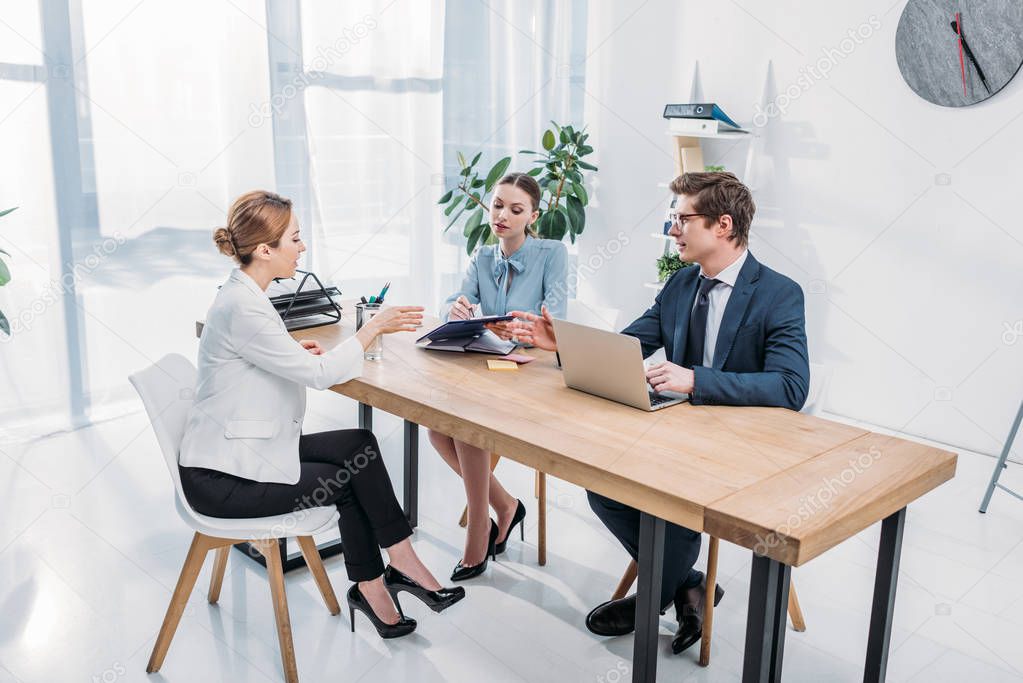 recruiter holding clipboard near coworker and women on job interview 