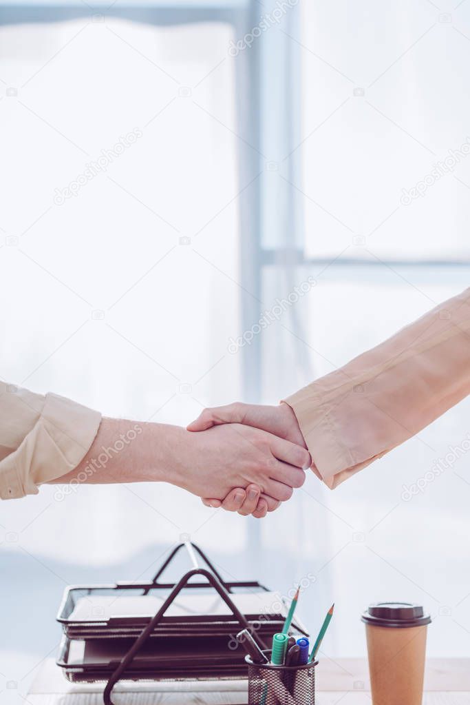 cropped view of recruiter and employee shaking hands 