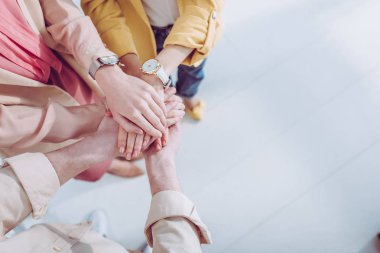 cropped view of man and women putting hands together  clipart