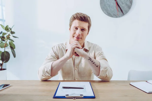 Cheerful Handsome Man Sitting Clenched Hands Clipboard Pen — Stock Photo, Image